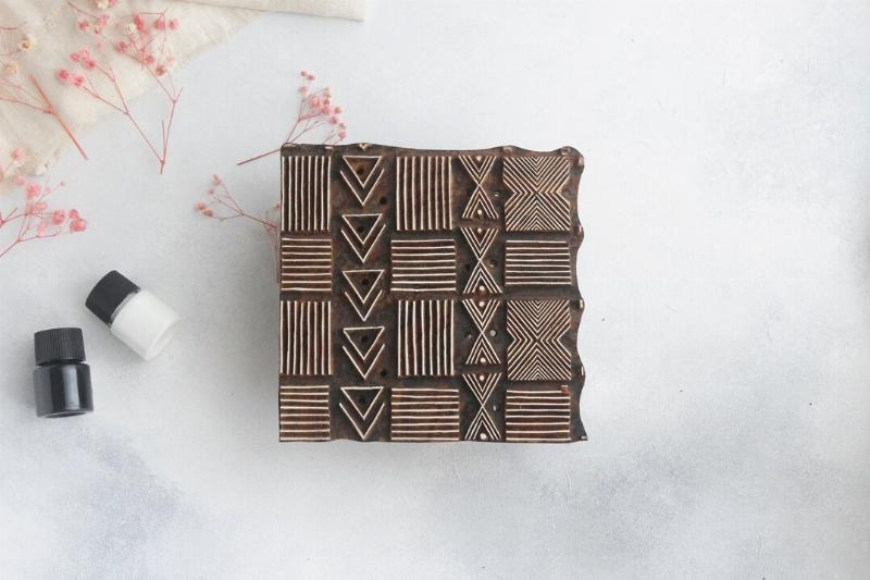 Un collectionneur examine minutieusement une sculpture africaine en ébène pour l’authentification et le prix